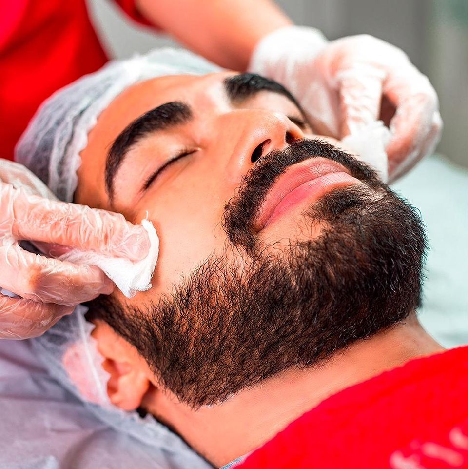 Profissional realizando limpeza de pele facial em cliente